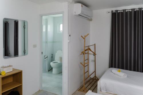 a white bathroom with a toilet and a glass door at The Princess Beachfront Resort in Ban Tha Fat
