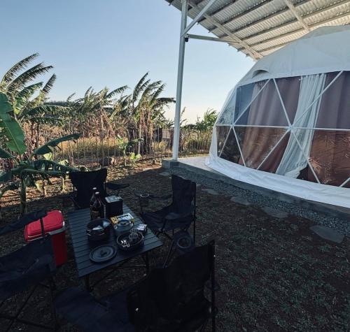 a tent with a table and chairs in a yard at CAELO | Peaceful Mountain View Rive in Pililla