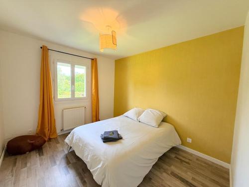 a bedroom with a bed with a bag on it at Le Cocon de Vabre, maison calme in Onet le Château