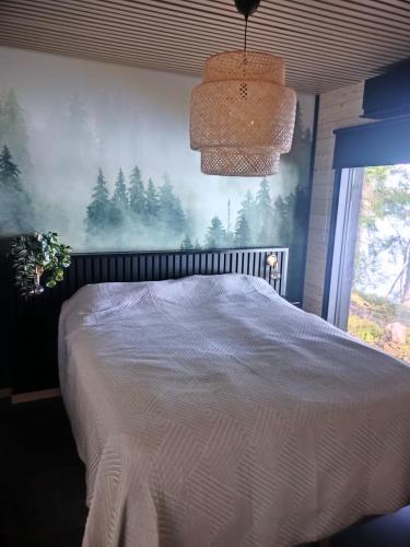 a bedroom with a bed with a painting on the wall at Villa Vaalanto in Pomarkku