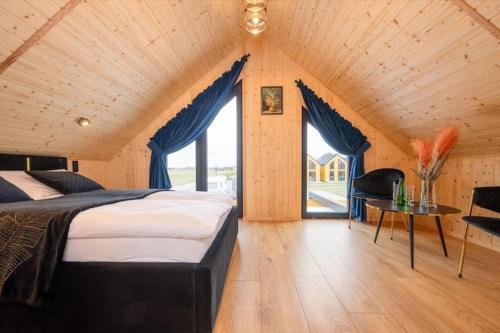 a bedroom with a large bed with blue drapes at Comfortable holiday home, pool, sauna, jacuzzi in Kopań