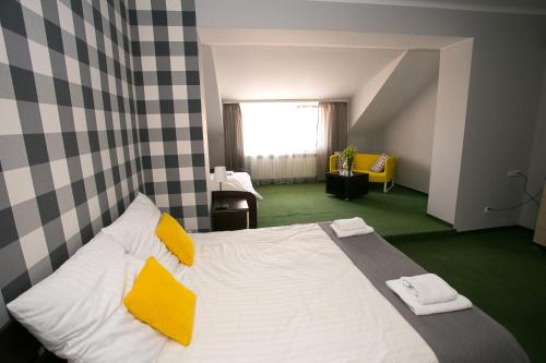 a bedroom with a large white bed with yellow pillows at Labirynt in Łomża