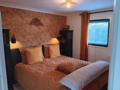 a bedroom with a large bed with a window at Vechtdal Chalet de Wilg in Rheezerveen