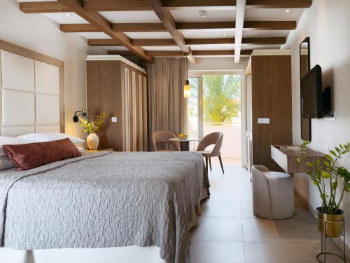 a bedroom with a large bed and a table and chairs at King Jason Paphos - Designed for Adults by Louis Hotels in Paphos