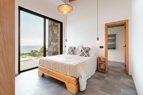 a bedroom with a bed and a large window at Casa Al Mare in Canto da Areia