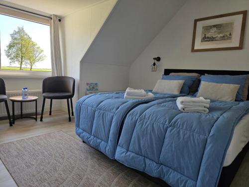 a blue bed with a blue comforter in a bedroom at B&B Bokkeleane in Kolderwolde