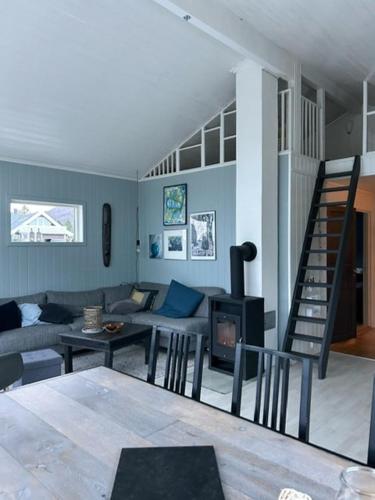 a living room with a couch and a table and a staircase at Charming Cabin With Archipelago Views In Sogn in Ånneland