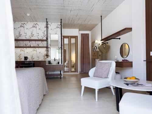 a living room with a white chair and a table at King Jason Paphos - Designed for Adults by Louis Hotels in Paphos