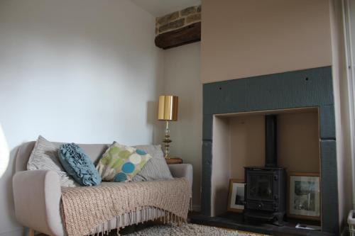 a living room with a couch and a fireplace at Hillside Cottage in Wirksworth