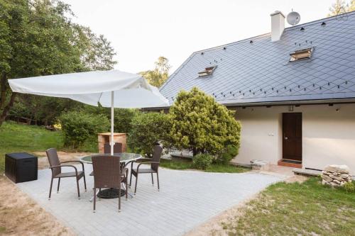 a patio with a table with an umbrella and chairs at Hájovna Bukovec in Bukovec