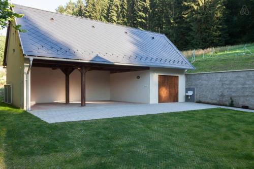 a building with a garage with a wooden door at Hájovna Bukovec in Bukovec