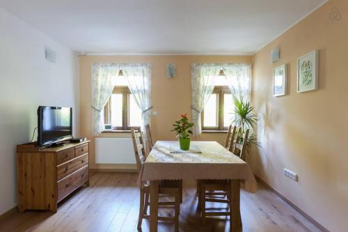 a dining room with a table and chairs and a television at Hájovna Bukovec in Bukovec