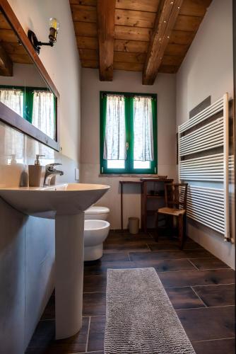 a bathroom with a sink and a toilet and windows at All'ombra della quercia in Fano