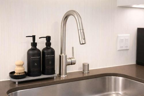 a kitchen sink with two bottles on a counter at Artistic Getaway 10 Min to Disneyland With Pool&GYM in Tustin