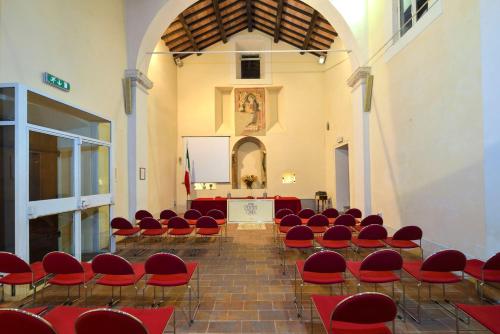 a room with red chairs and a podium in a church at Hotel Fonte Cesia in Todi