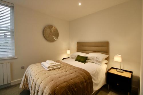 a bedroom with a bed with towels on it at Penthouse new 2 bed 2 apartment in Basingstoke