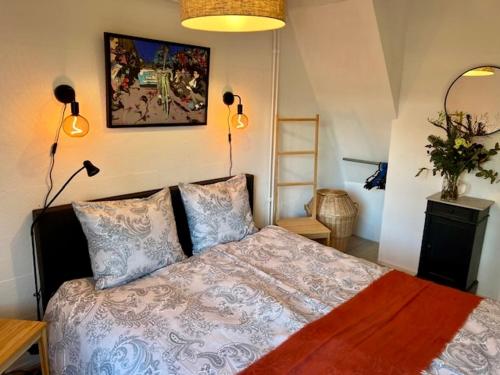 a bedroom with a bed with two lamps and a picture on the wall at Vakantiebungalow Maison7 in Plombières