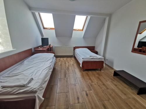 a bedroom with two beds and a wooden floor at Hostel RAV in Tomaszów Mazowiecki