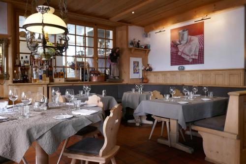 a dining room with tables and chairs and a chandelier at Hotel Traube in Scuol