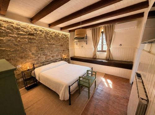 a bedroom with a bed and a stone wall at Tenuta di Valmarino - Adults only in Corciano