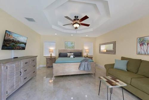 a bedroom with a bed and a couch and a ceiling fan at Home with pool by Dream Vacation in Fort Lauderdale