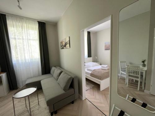a living room with a couch and a bedroom at Hotel Miramar in Sopot