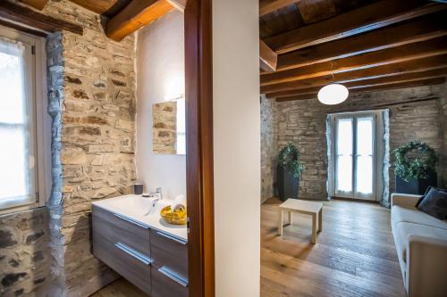 a kitchen and living room with a stone wall at Borgo Molina in Faggeto Lario 