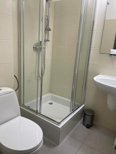 a bathroom with a shower and a toilet and a sink at Hotel Miramar in Sopot