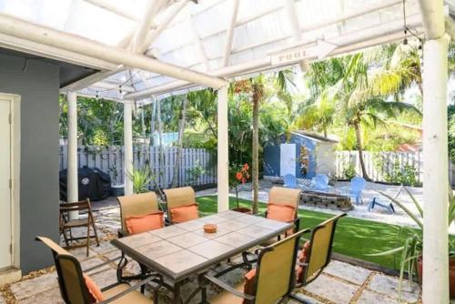 a patio with a table and chairs and a glass roof at Peacock Villa 2 by Dream Vacation in Fort Lauderdale