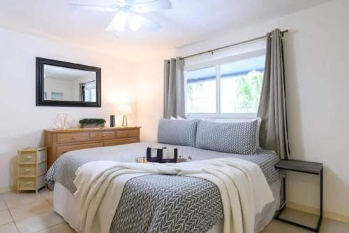 a bedroom with a bed with a mirror and a window at The peacock villa 1 by Dream Vacation in Fort Lauderdale