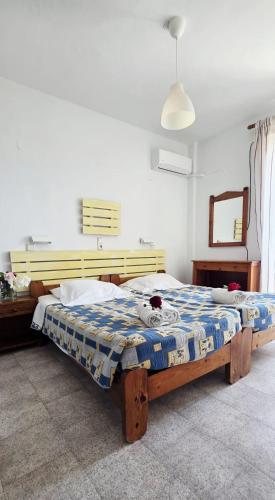 a bedroom with a bed with a blue and white blanket at Marika Apartments in Mastihari