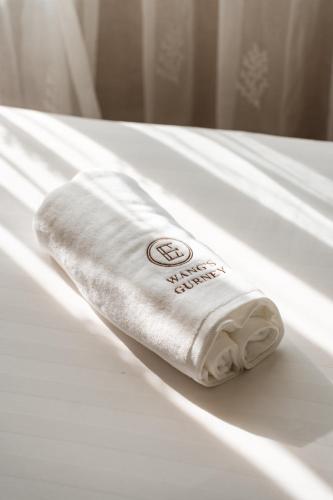 a white towel sitting on top of a bed at Wangs Hotel Gurney Drive in George Town