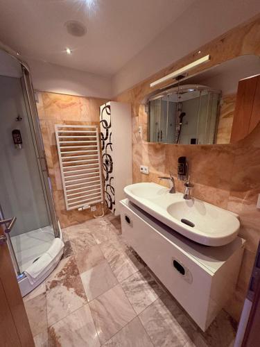 a bathroom with a sink and a shower at Sidan Hotel Restaurant & Pizzeria in Schwendau