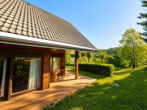a house with a wooden porch with a patio at Renovated Apartment ŽAJBELJ near Terme Topolšica in Topolšica
