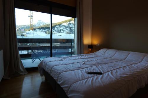 a bed in a bedroom with a large window at Soldeu Paradis Clos in Soldeu