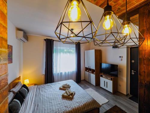 a bedroom with a bed and a television and lights at Ben Apartments Near City Center in Sibiu