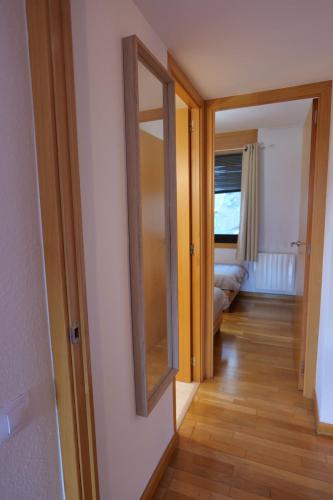 a hallway with a mirror and a door to a room at Soldeu Paradis Clos in Soldeu