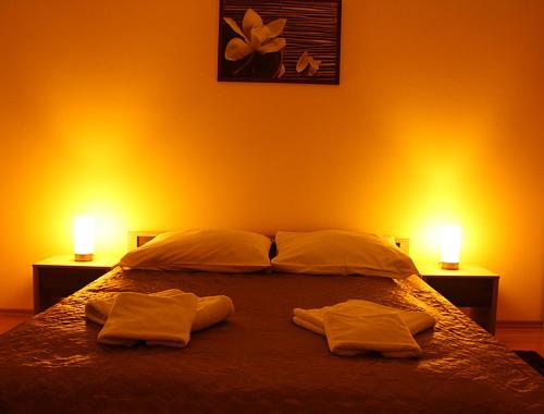 シュチェチンにあるApartament Luxusのベッドルーム1室(タオル2枚、ベッド1台、照明2つ付)