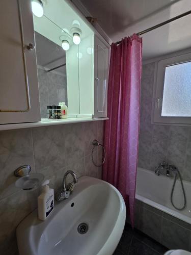 a bathroom with a sink and a pink shower curtain at Sidirounda Traditional House 1 in Sidiroúnta