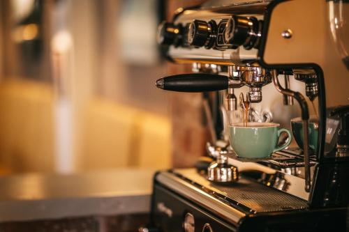 a coffee machine with a cup on top of it at Boot & Shoe in Flintham