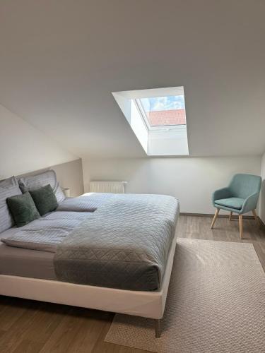 a bedroom with a bed and a window and a chair at Penzion Klas in Měřín