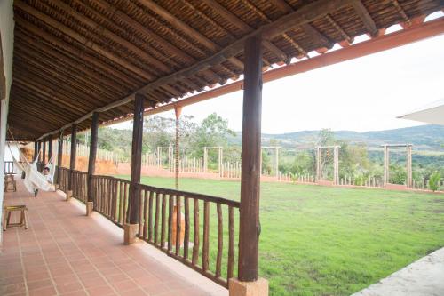 a woman sitting on a porch looking at a soccer field at Hotel Boutique Venturi in Barichara