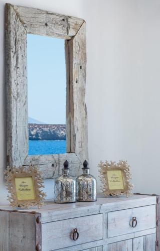 a dresser with two jars on it with a window at Aelia Paros Beachfront Villas-Member of My Villas Hospitality in Chrissi Akti