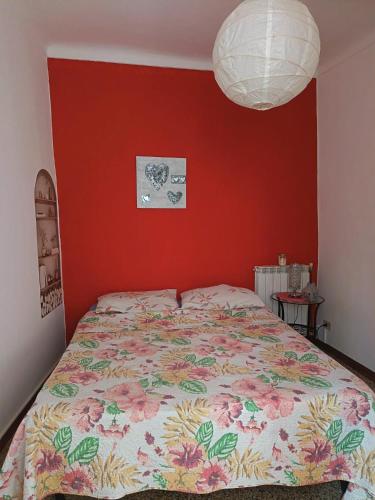 a bed in a bedroom with a red wall at Limonaia in Villa Viani