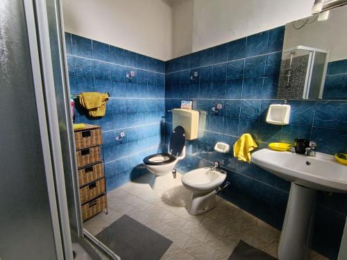 a blue tiled bathroom with a toilet and a sink at Limonaia in Villa Viani