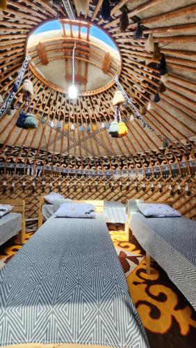 a large room with two beds on a boat at Keremet Yurt in Bokonbayevo