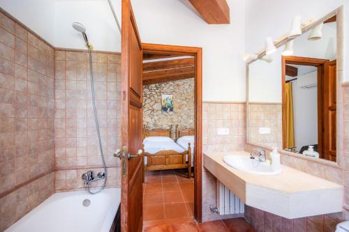 a bathroom with a tub and a sink and a shower at Villa Cal Apostol in Pollença