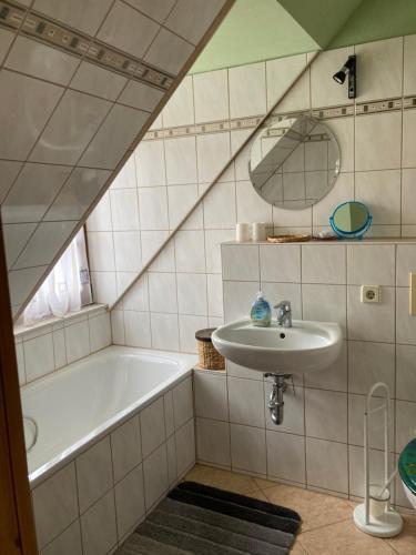 a bathroom with a bath tub and a sink at Ferienwohnung Haubitz in Borna