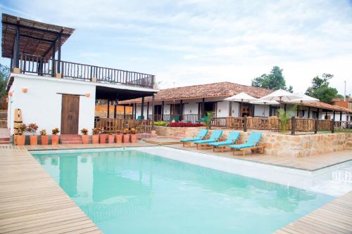 a pool at a resort with chairs and a building at Hotel Boutique Venturi in Barichara