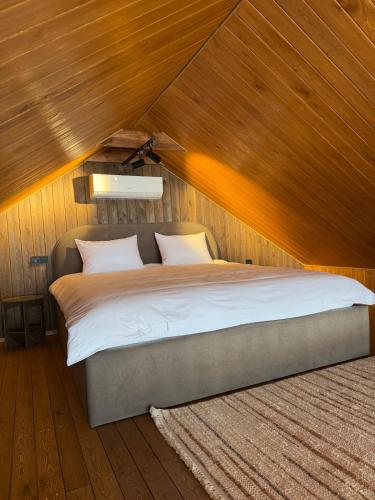 a bedroom with a large bed with a wooden ceiling at Bruno House in Almaty